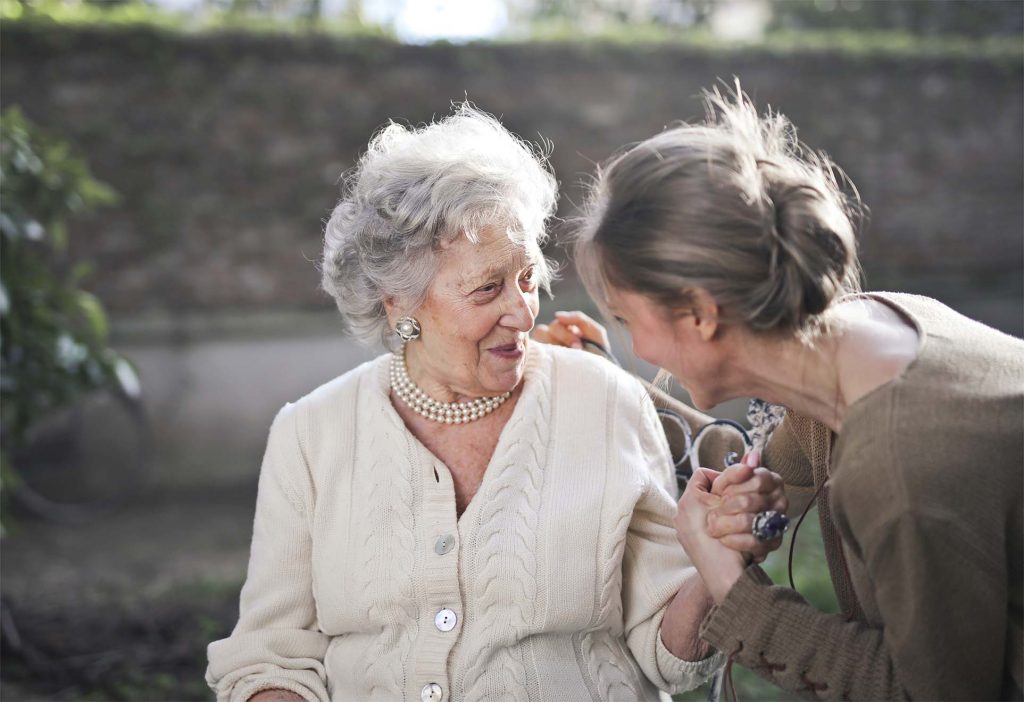 care home staff helping old lady